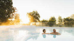 twee mensen ontspannen in het buitenzwembad van de thermae twee mensen ontspannen in het buitenzwembad van de thermae