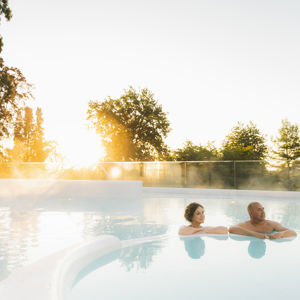 twee mensen ontspannen in het buitenzwembad van de thermae twee mensen ontspannen in het buitenzwembad van de thermae