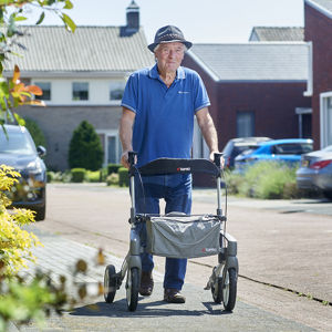 meneer achter een rollator maakt een wandeling buiten meneer achter een rollator maakt een wandeling buiten