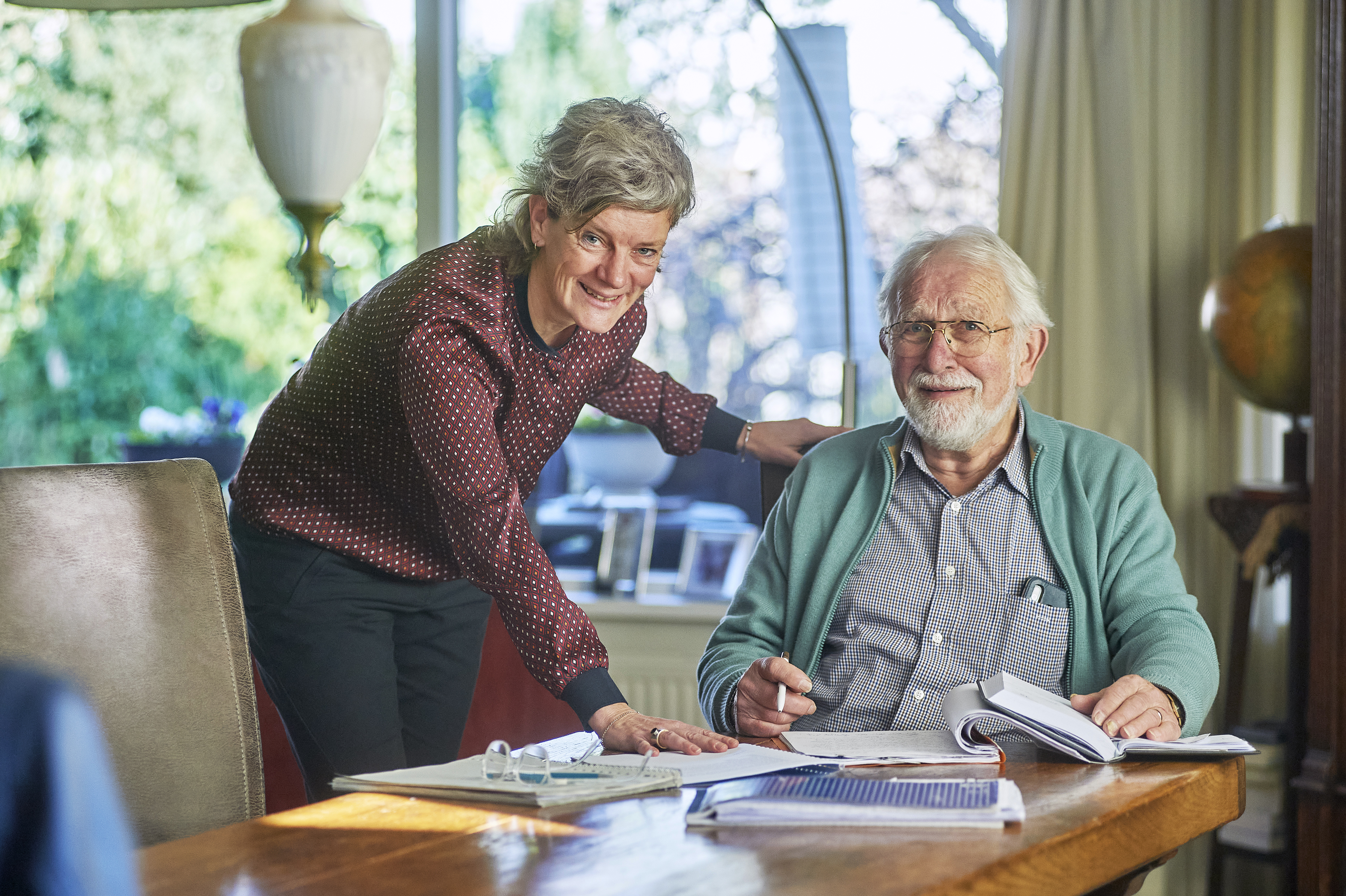 medewerker van zicht op geld helpt meneer bij zijn administratie