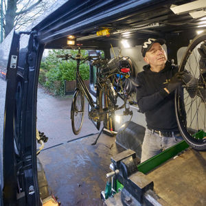 fietsmaker aan huis repareert een fiets in zijn werkbus fietsmaker aan huis repareert een fiets in zijn werkbus
